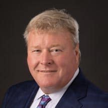 Portrait of John Fitzgerald, President & CEO of Magyar Bank, smiling warmly.